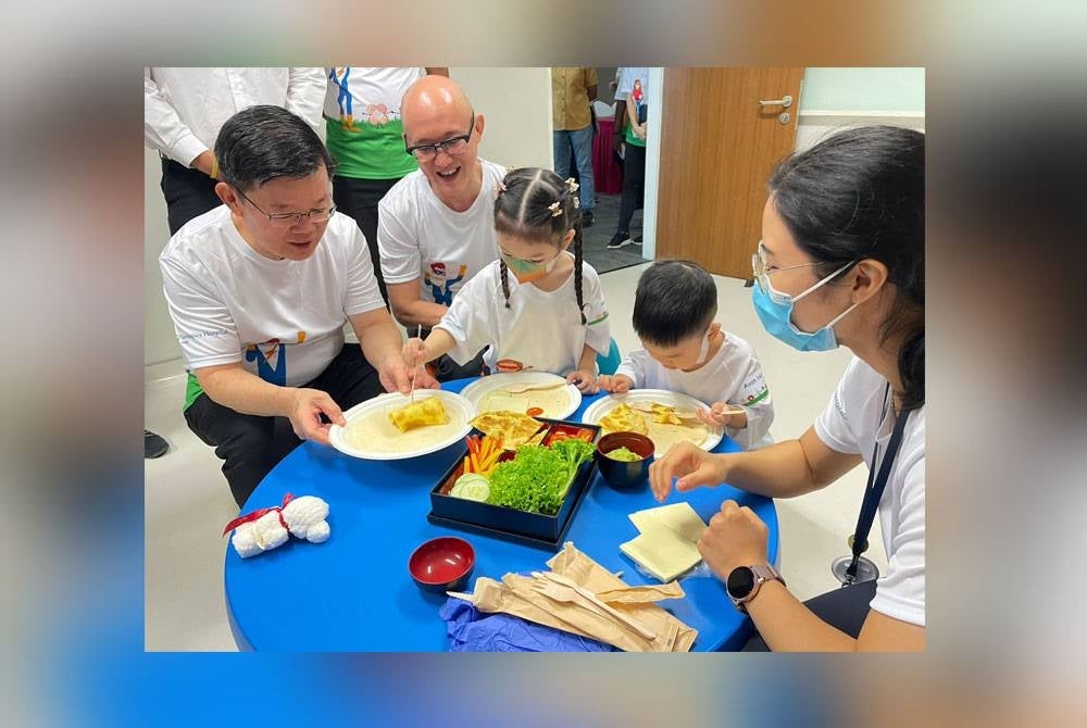 Kon Yeow (kiri) melayani kanak-kanak ketika melakukan salah satu aktiviti dalam The Interactive Edutainment Programme sambil diperhatikan Ivan di Hospital Gleneagles Pulau Pinang.