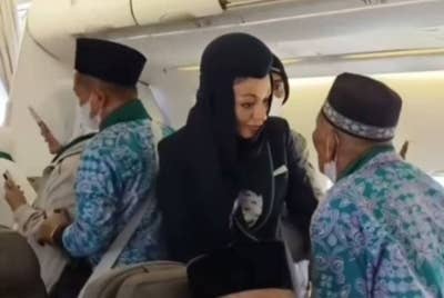 Juhani menghampiri pramugari dan memberitahu terlupa memberi makan ayam peliharaannya. - Foto Agensi