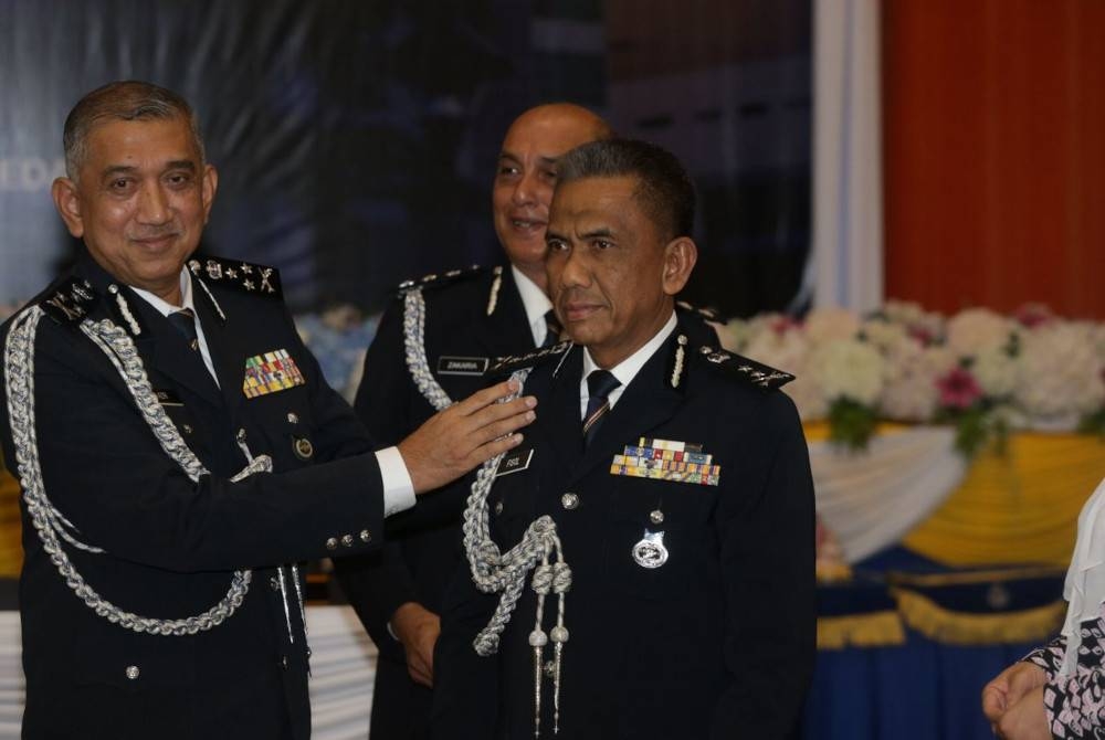 Azri (kiri) melaksanakan upacara pemakaian pangkat Komisioner Polis (CP) kepada Fisol sebelum majlis serah terima tugas berlangsung di Dewan Tunku Ibrahim, Ibu Pejabat Polis Kontinjen Kedah pada Selasa.
