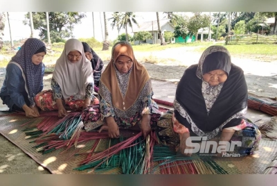 Zizah (dua dari kiri) menganyam tikar daripada pokok kercut.