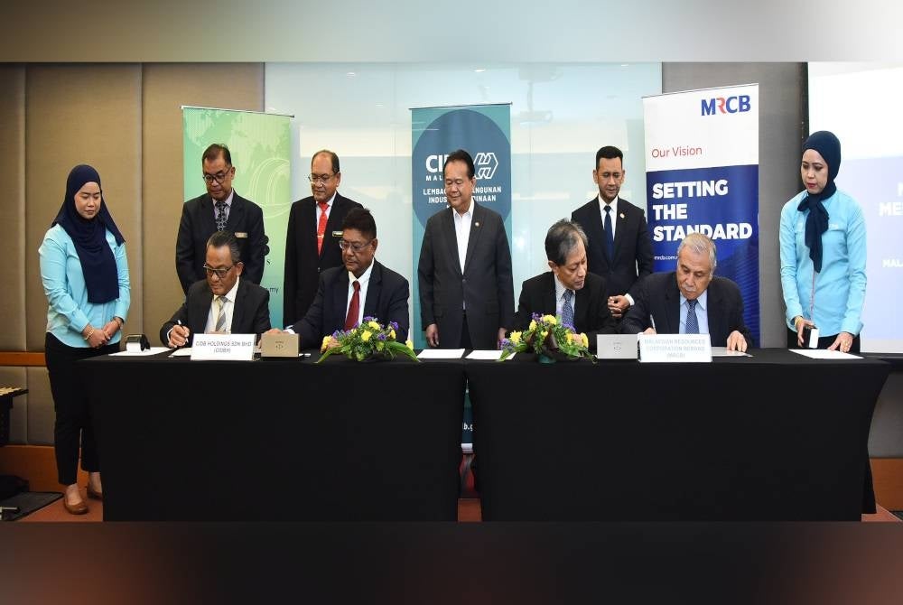 Alexander (tengah) menyaksikan wakil CIDB dan MRCB menandatangani MoU untuk bekerjasama dalam meningkatkan kebolehpasaran graduan TVET di Malaysia.