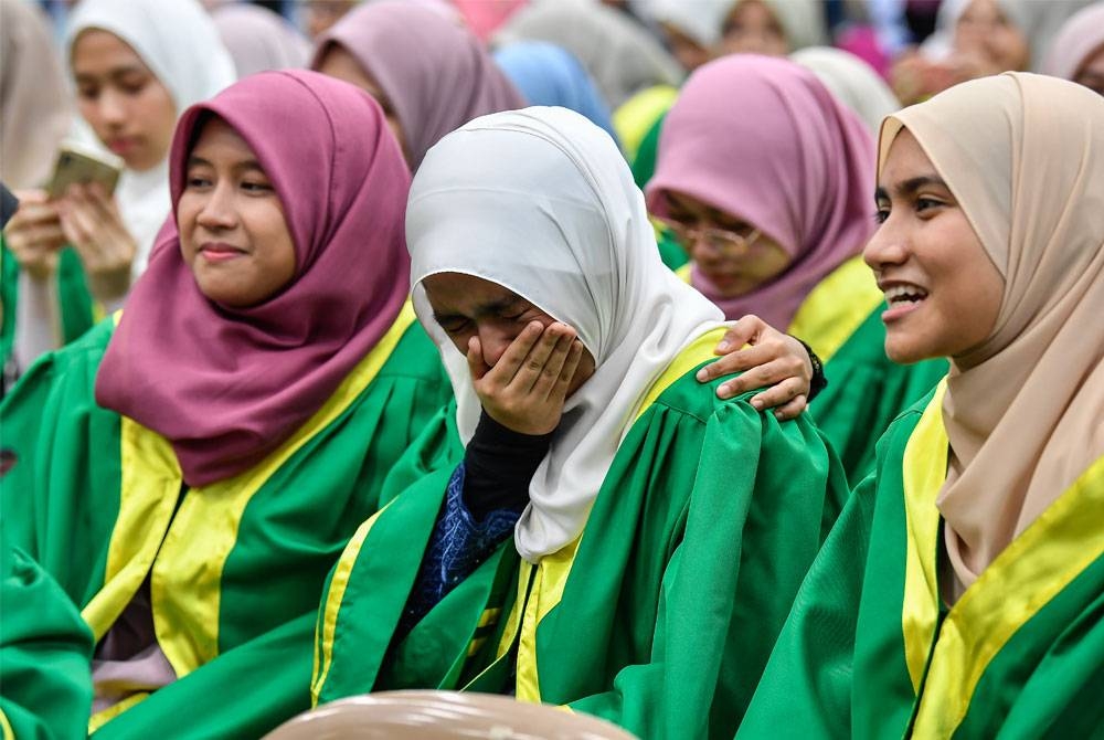 Reaksi calon SPM 2022, Nurul Adilah Hikmah Norasri (tengah) kelihatan sebak ketika meraikan kecemerlangannya memperoleh 11A dalam peperiksaan SPM di Sekolah Menengah Agama Majlis Agama Islam Wilayah Persekutuan Kuala Lumpur pada Khamis. - Foto Bernama