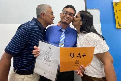 Kedua-dua ibu bapa Bhuvenraj (tengah) berbangga dengan pencapaiannya selepas muncul sebagai salah seorang pelajar terbaik SPM 2022 Pulau Pinang.