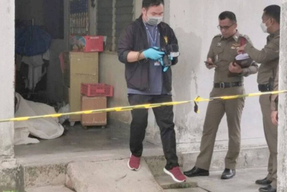 Anggota polis menyiasat kejadian di kompleks perumahan di wilayah Nonthaburi. - Foto Agensi
