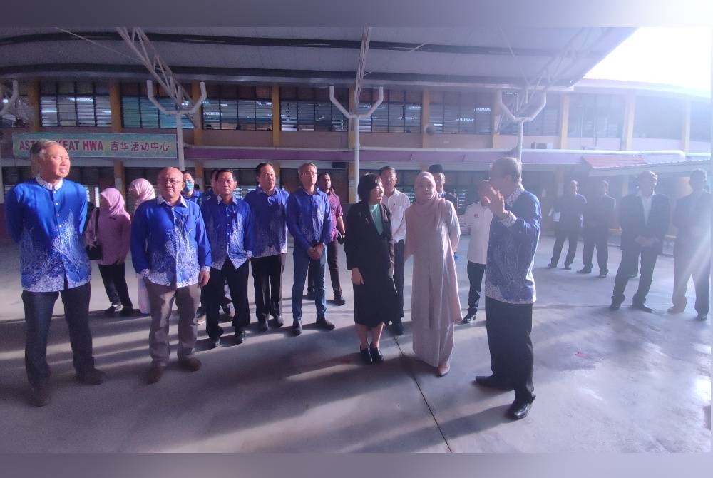 Fadhlina Sidek (dua dari kanan) mendengar penerangan ketika lawatan ke SMJK Keat Hwa di Jalan Kuala Kedah pada Ahad.