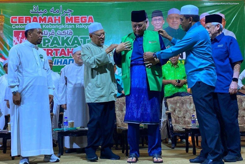 Takiyuddin (kanan) memakaikan jaket berlogo Pas kepada Annuar semasa Ceramah Mega Gelombang Kebangkitan Rakyat di Dataran Warisan Stadium Sultan Muhammad IV, Kota Bharu pada Ahad.