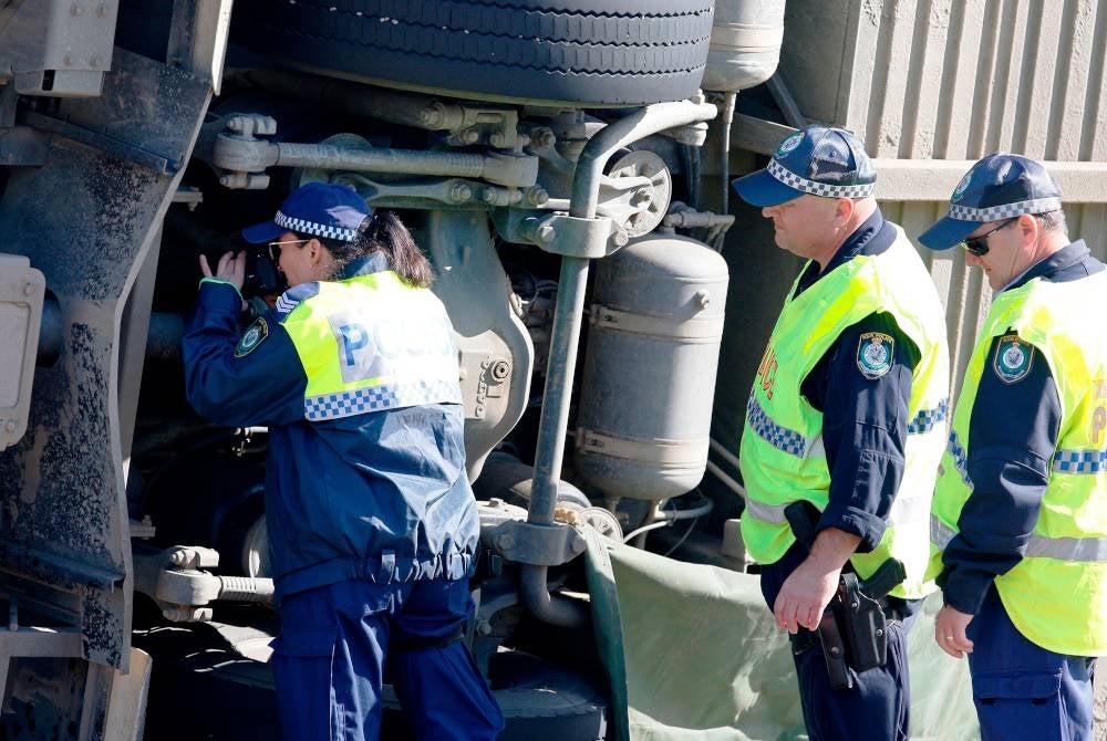 Anggota penyiasat di lokasi kemalangan sebuah bas yang mengorbankan 10 penumpang dan menyebabkan puluhan lain cedera. - Foto EPA