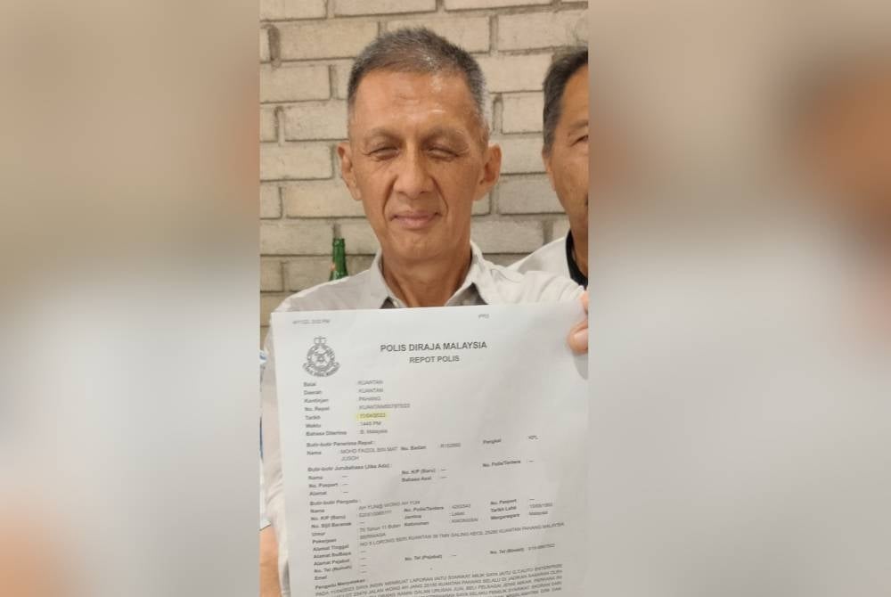 Donald Chan menunjukkan salinan laporan polis yang dibuat ahli persatuan selepas nama dan maklumat kedai digunakan sindiket penipuan untuk urusan jual beli kereta terpakai tidak wujud.