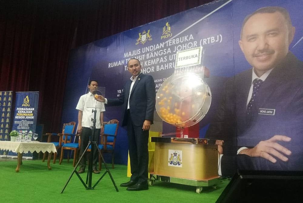 Mohd Jafni (kanan) pada Majlis Undian Terbuka RTBJ Taman Kempas Utama di Dewan Serbaguna Majlis Bandaraya Iskandar Puteri (MBIP), pada Selasa.