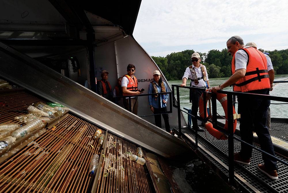 Nik Nazmi (dua dari kanan) melihat perangkap sampah 'The Ocean Cleanup' ketika mengadakan lawatan kerja melawat Sungai Klang pada Selasa. - Foto Bernama