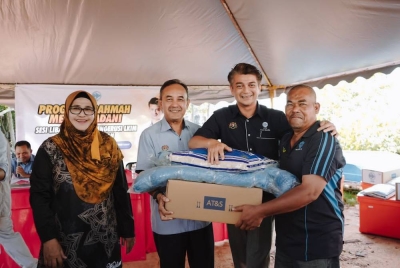 Muhammad Faiz (dua dari kanan) menyerahkan bantuan 'touch point' kepada nelayan pada lawatan kerja ke Unit Nelayan Bujang dalam program Rahmah Mesra Madani, baru-baru ini.