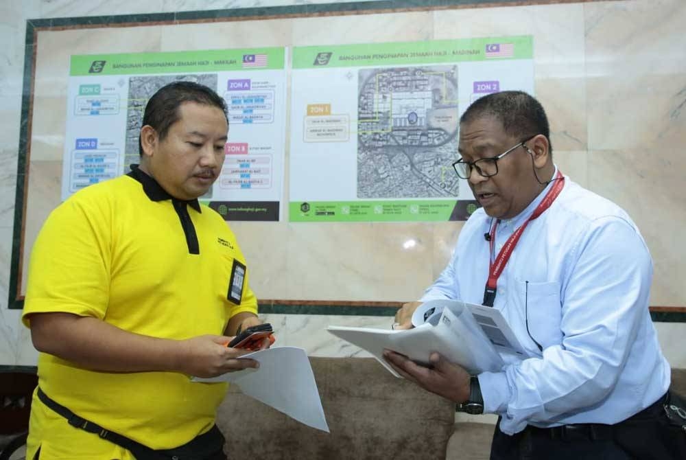 Hamadah (kiri) dan Anuar berbincang mengenai tugasan mereka untuk membantu jemaah haji di Abraj Janadriyah.