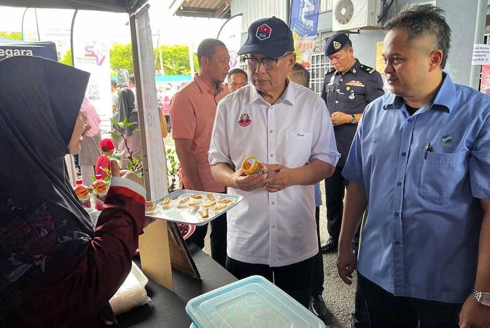 Mohd Puad (dua dari kiri) mengadakan lawatan di Bazar Rakyat Agro Johor di Pusat Memproses Makanan Fama, Rengit pada Rabu.
