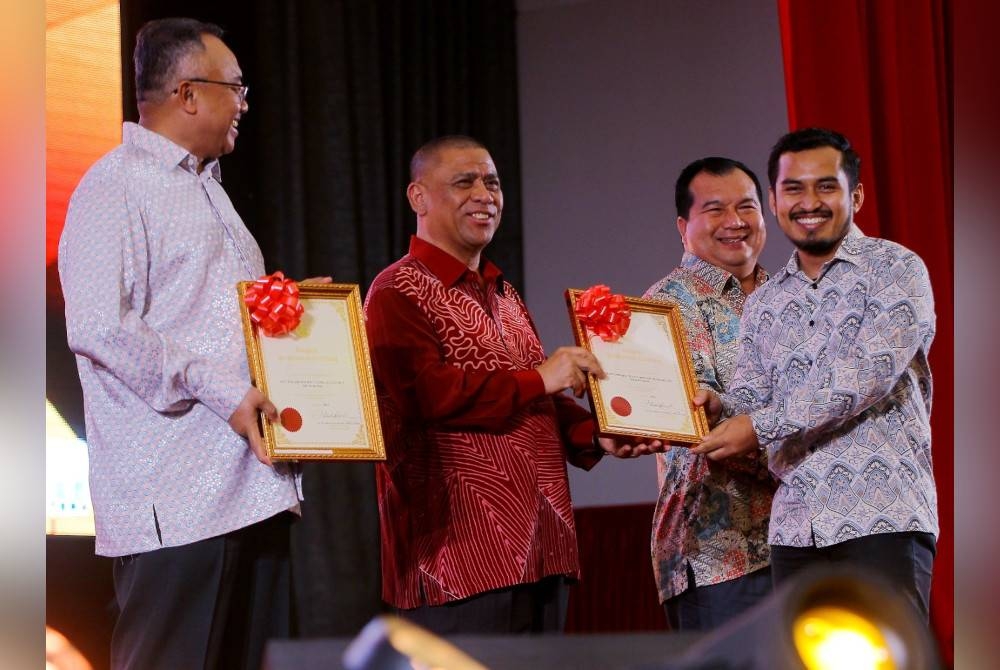 Saarani (dua dari kanan) menyampaikan sijil penghargaan APC kepada Mohammad Faiz Izzuddin Zulkarnain yang berkhidmat di Bahagian Korporat SUK Perak.