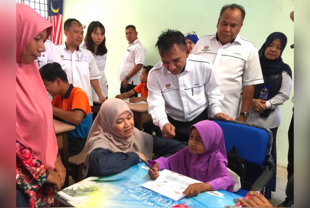 Fadhlina (dua dari kiri) bermesra dengan pelajar di Sekolah K9 SK Pulau Beluru, Tumpat.