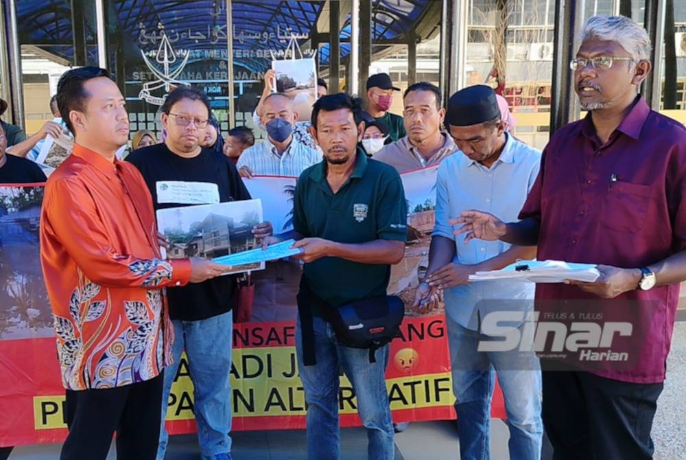 Nor Samsi (depan, tengah) mewakili penduduk Kampung Insaf menyerahkan memorandum isu banjir kepada Wan Emril Nizam (kiri) di luar pejabat Menteri Besar Pahang di Wisma Sri Pahang pada Khamis.