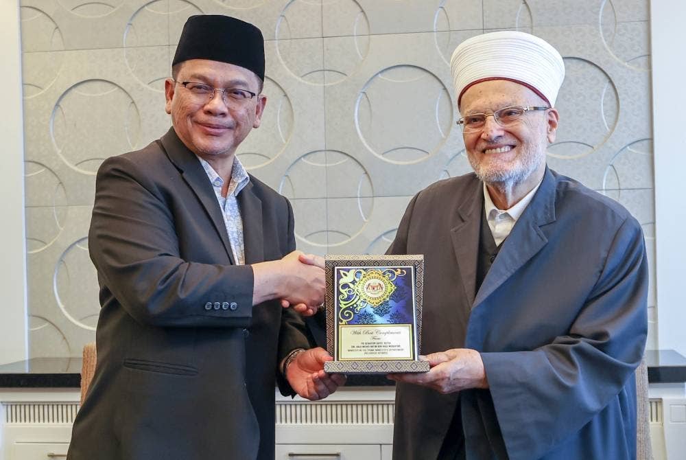 Mohd Na'im menyampaikan cenderahati kepada Syeikh Dr Ekrima Sabri semasa menerima kunjungan hormat Imam Besar Masjid Al Aqsa itu di Kompleks Islam Putrajaya, pada Khamis. - Foto Bernama