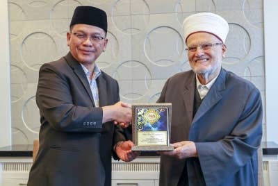 Mohd Na'im menyampaikan cenderahati kepada Syeikh Dr Ekrima Sabri semasa menerima kunjungan hormat Imam Besar Masjid Al Aqsa itu di Kompleks Islam Putrajaya, pada Khamis. - Foto Bernama