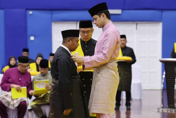 Tengku Hassanal berkenan mengurniakan darjah kebesaran SMP kepada Amirul Hamizan pada Istiadat Pengurniaan Darjah Kebesaran dan Pingat Negeri Pahang Sempena Memuliakan Ulang Tahun Hari Keputeraan Ke-63 Sultan Pahang di Dewan Jubli Perak, Sultan Haji Ahmad Shah, Kuala Lipis pada Khamis. - Foto Bernama