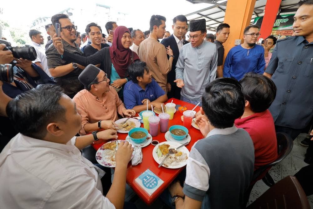 Anwar menyapa orang ramai ketika hadir meluangkan masa makan tengah hari bersama rakyat di Medan Selera Sports Arena pada Jumaat. - Foto Bernama
