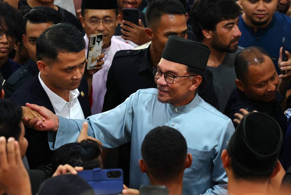 Anwar bersalaman dengan para jemaah selepas menunaikan solat jumaat di Masjid Raja Haji Fisabilillah hari ini. - Foto Bernama