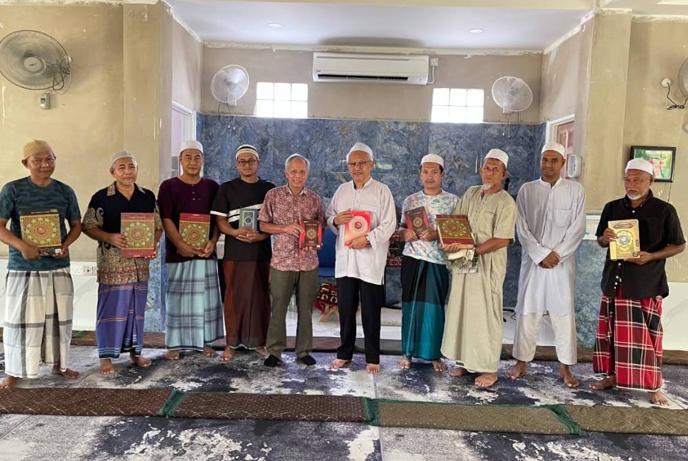 Mohd Nasir (lima dari kiri) menyampaikan sumbangan al-Quran kepada Ahli Jawatankuasa Masjid Iktikaf Noor Muhamad Kampung Belian.