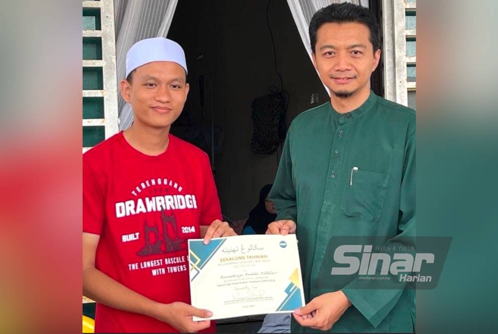 Mohd Syahir (kanan) menyampaikan sijil tahniah kepada Muhammad Syahril pada Sabtu.