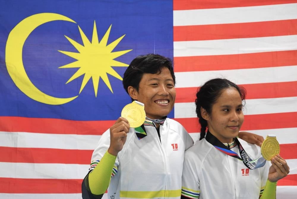 Nur Azlia Syafinaz (kanan) dan Nurul Syuhada menunjukkan pingat emas yang dimenangi mereka. - Foto Bernama
