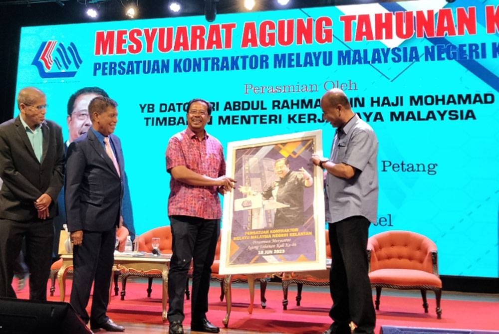 Abdul Rahman (tiga dari kiri) menerima cenderamata daripada Mohd Rosdi pada Mesyuarat Agung Tahunan Kali Ke-46 Persatuan Kontraktor Melayu Malaysia Negeri Kelantan pada Ahad.
