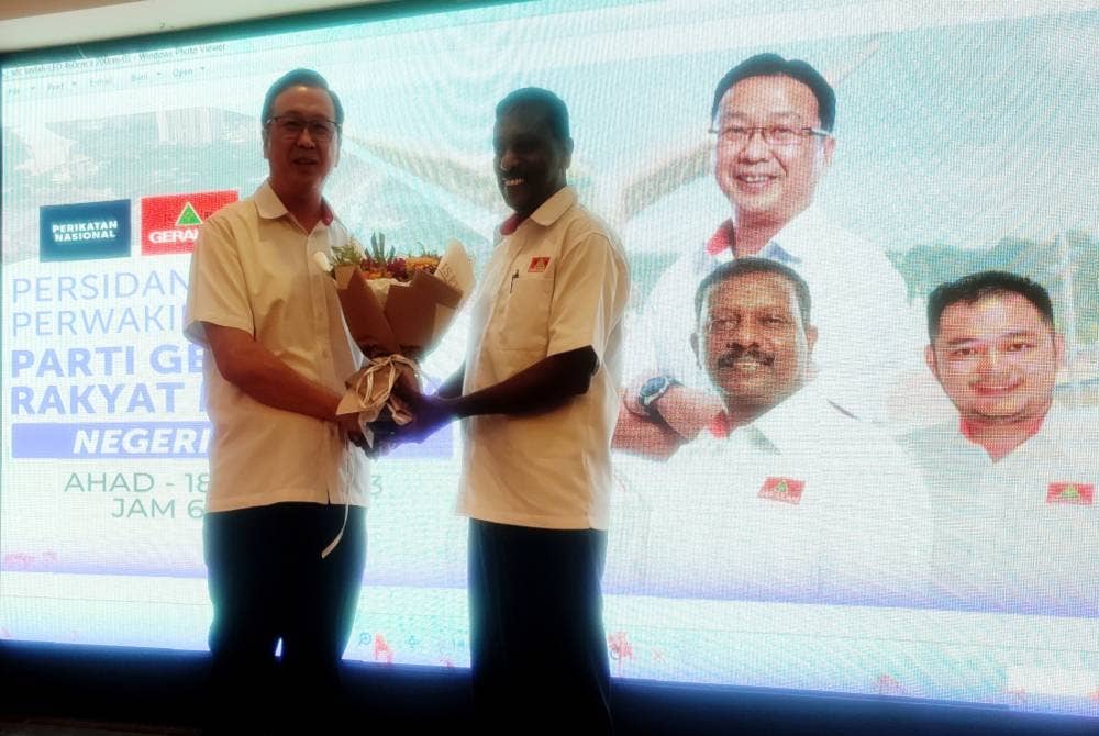 Dr Dominic (kiri) menyerahkan bunga sebagai tanda penghargaan kepada mantan Pengerusi Gerakan Kedah, Marimuthu Selvan pada Persidangan Perwakilan Tahunan Parti Gerakan Kedah 2023 di Taman Aggerik, di Alor Setar pada petang Ahad.