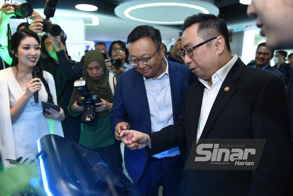 Lih Kang (kanan) yang diiringi Li Pu menandatangani plak perasmian Proton DX. - Foto Sinar Harian MOHD RAFIQ REDZUAN HAMZAH