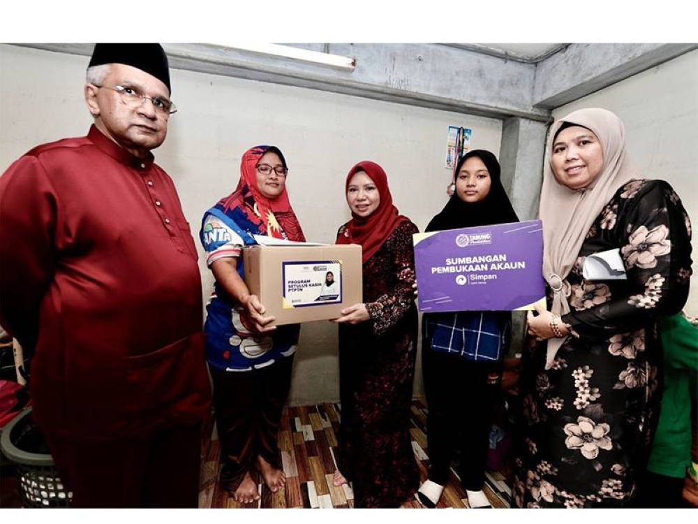 Norliza (tiga dari kiri) menyantuni salah seorang penerima sumbangan semasa sesi ‘walkabout’ di Flat Kampung Melayu, Pulau Pinang.