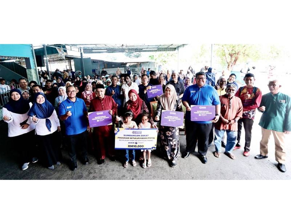 Norliza (tengah)bergambar bersama penerima sumbangan Program Setulus Kasih PTPTN yang diadakan di Surau Kampung Melayu, Ayer Hitam Pulau Pinang.