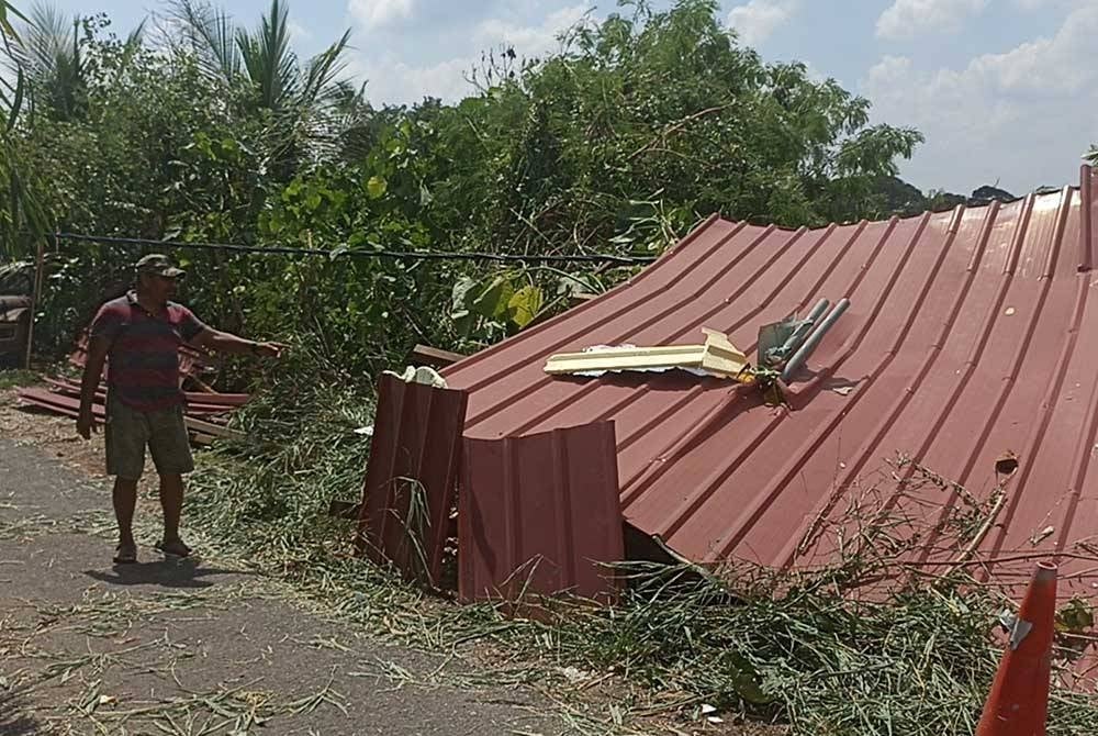 Penduduk menunjukan bumbung sekolah yang diterbangkan angin di Kampung Tahang Rimau.