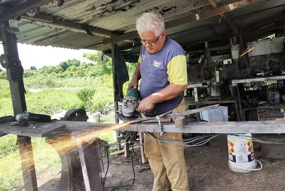 Nasir sedang menyiapkan salah satu tempahan parang oleh pelanggan di rumahnya di Kampung Gelugur Kedai di Kuala Terengganu.