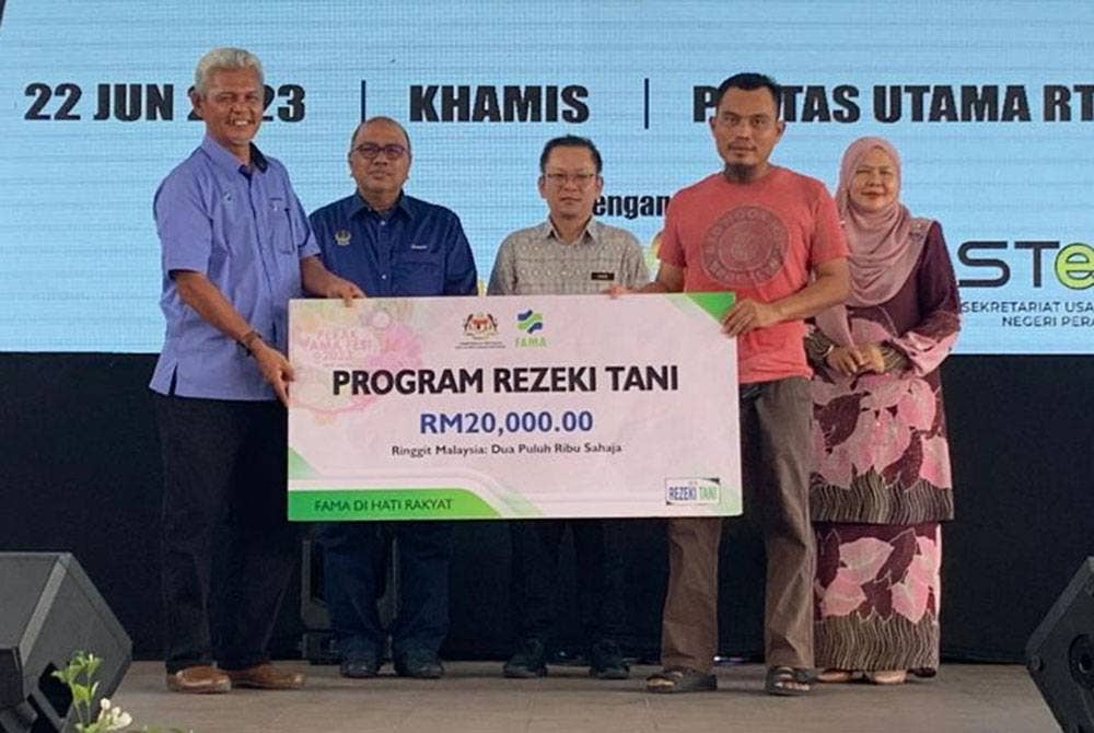 Foong Hin (tengah) menyampaikan insentif program Rezeki Tani berjumlah RM20,000 kepada penerima pada Perak FAMA Fest 2023 di RTC Perak, Gopeng.