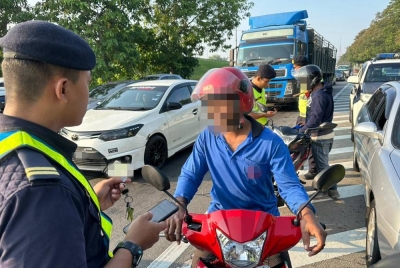 Pegawai JPJ melakukan pemeriksaan terhadap penunggang motosikal warga asing dalam Ops Pewa di Seberang Jaya pada Khamis.