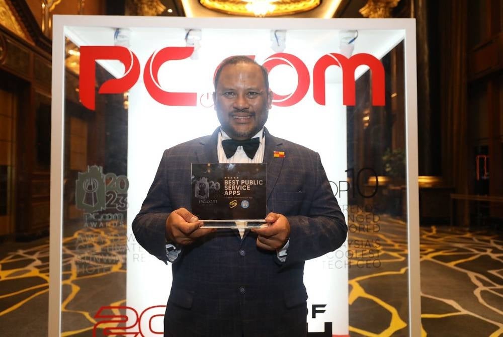 Ramli bergambar bersama anugerah dimenangi KDEBWM pada Majlis Malam Anugerah PC.COM di Sunway Hotel Resort and Spa.