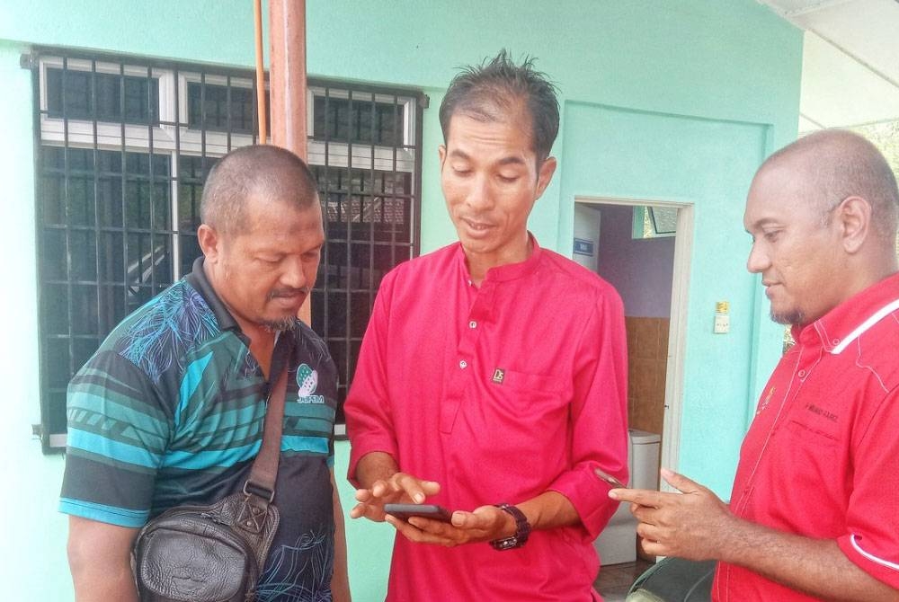 Muhamad Fariz (kanan) bersama dua lagi kakitangan Jupem yang turut berada di Hospital Jelebu.