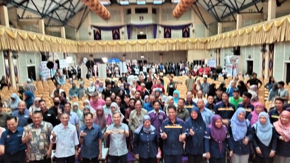 Fahmi (depan, lima dari kiri) menunjukkan 'mini love' ketika bergambar kenangan bersama warga di UiTM Cawangan Kampus Machang selepas merasmikan Jelajah Saya Digital 2023 Kelantan pada Sabtu.