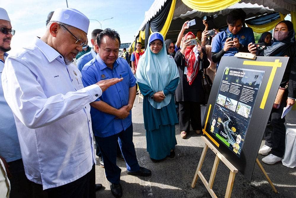 Menteri Kerja Raya Datuk Seri Alexander Nanta Linggi (dua, kiri) mendengar penerangan daripada Menteri Besar Kelantan Datuk Ahmad Yakob (kiri) mengenai pelan projek pembinaan jejambat dari arah Kota Bharu merentangi Bulatan Wakaf Bharu ke Pengkalan Kubor pada majlis perasmian jejambat tersebut hari ini.