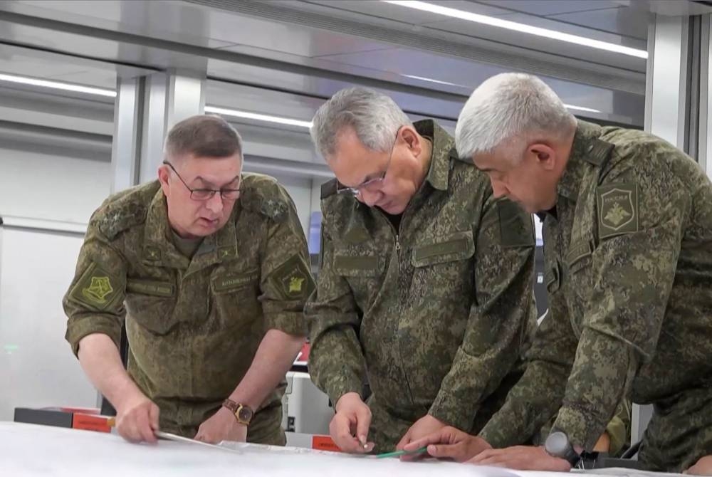 Rakaman tersebut memaparkan Shoigu (tengah) dan beberapa pegawai kanan tentera Rusia sedang mengkaji peta di sebuah lokasi dirahsiakan. - Foto AFP