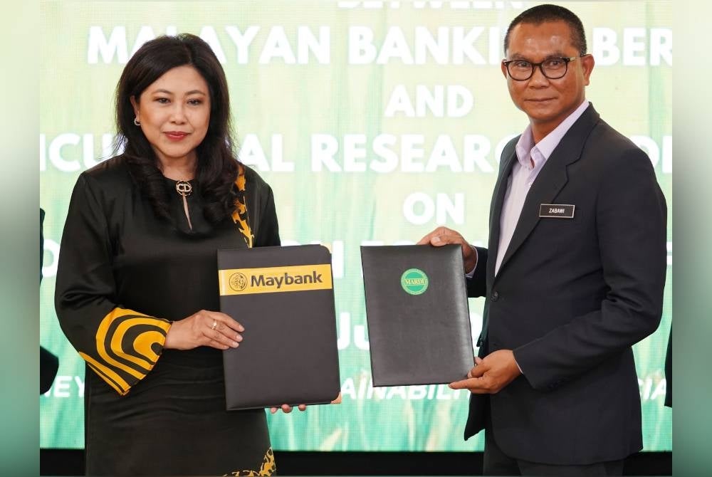 Mohamad Zabawi dan Nora bersama dokumen MoU perjanjian kerjasama bagi memacu inovasi dan pembangunan mampan dalam pertanian bandar di Akademi Maybank di Bangi, Selangor.