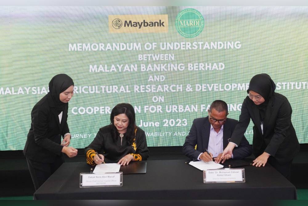 Mohamad Zabawi dan Nora memeterai Memorandum Persefahaman (MoU) bagi kerjasama memacu inovasi dan pembangunan mampan dalam pertanian bandar di Akademi Maybank di Bangi, Selangor.