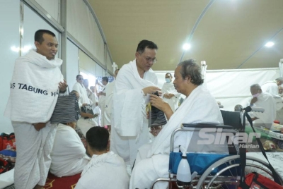 Mohd Na'im menyampaikan cenderahati kepada jemaah yang terlibat dalam program Peneman.