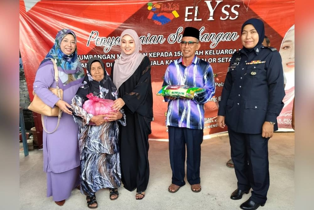 Auni (tiga dari kanan) menyerahkan sumbangan barang keperluan kepada penerima terpilih di Kuala Kangkong di sini pada Selasa.