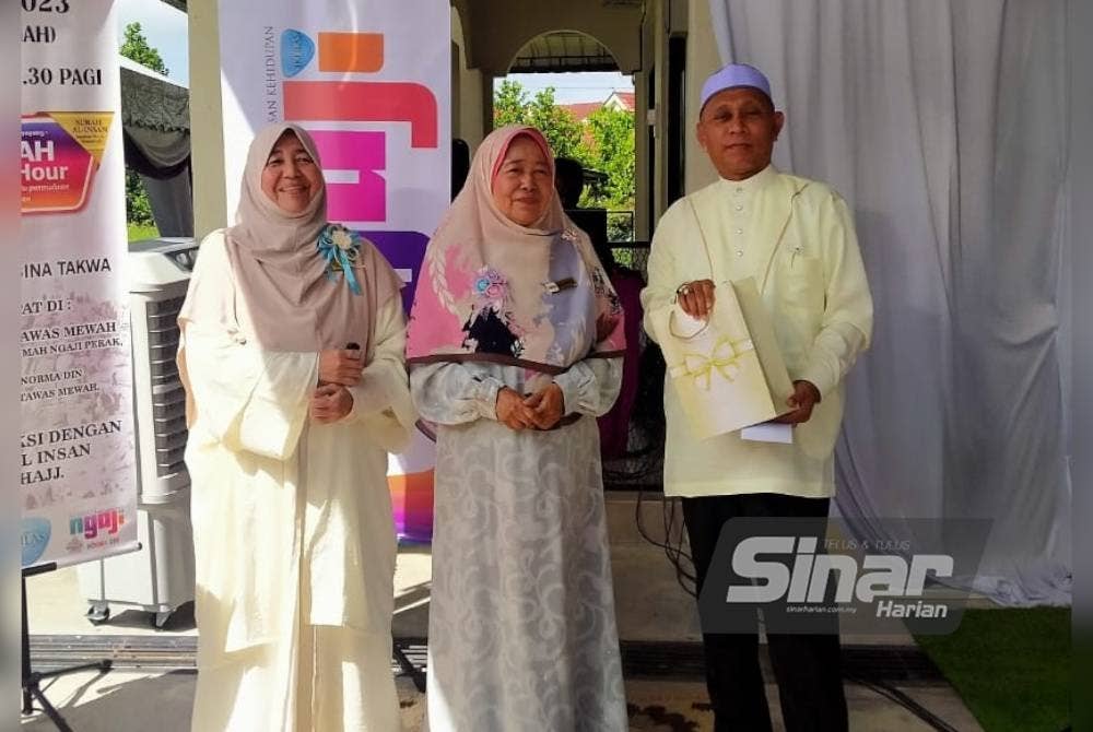 Normah Hanum (dua dari kanan) menyampaikan cenderahati kepada pentadabbur, Ridzuan Mohd Noor sempena program Arafah #QuranHour peringkat negeri Perak di Taman Tawas Mewah pada Rabu.