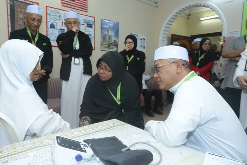 Mohd Na'im (kanan) bertanyakan tentang kesihatan seorang jemaah di Pusat Rawatan TH di Makkah.