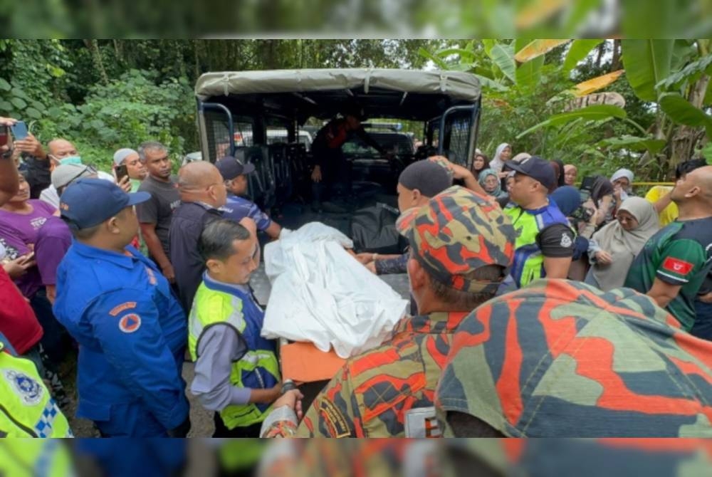 Anggota penyelamat mengangkat mangsa lemas di Sungai Kelantan di Kampung Pasir Pekan Hulu.