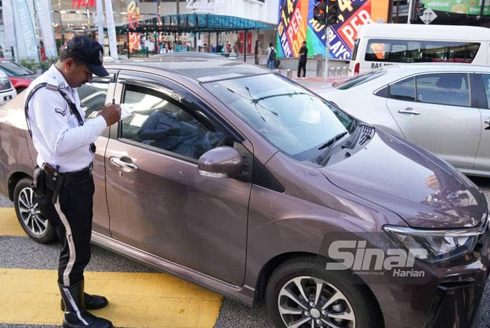 Anggota polis mengenakan saman kepada pesalah lalu lintas semasa Operasi Hormat Undang-Undang Jalan Raya Polis Kuala Lumpur dilakukan di Kuala Lumpur pada Isnin. Foto: SINAR HARIAN/Rosli Talib.